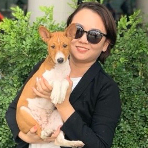 Người phụ nữ bế chú chó Basenji màu nâu trắng đáng yêu.