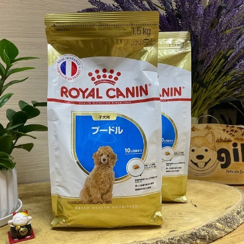 Túi thức ăn Royal Canin cho chó Poodle đặt trên bàn gỗ.