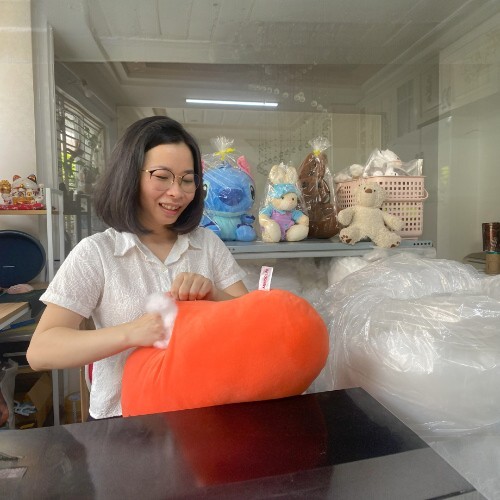 Nhân viên đang nhồi bông cho một sản phẩm gấu bông tại xưởng sản xuất.